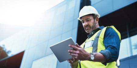Photo of construction professional looking at tablet device