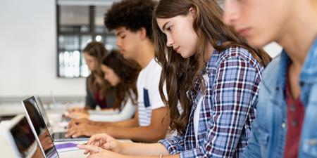 Photo of high school students working on their laptops