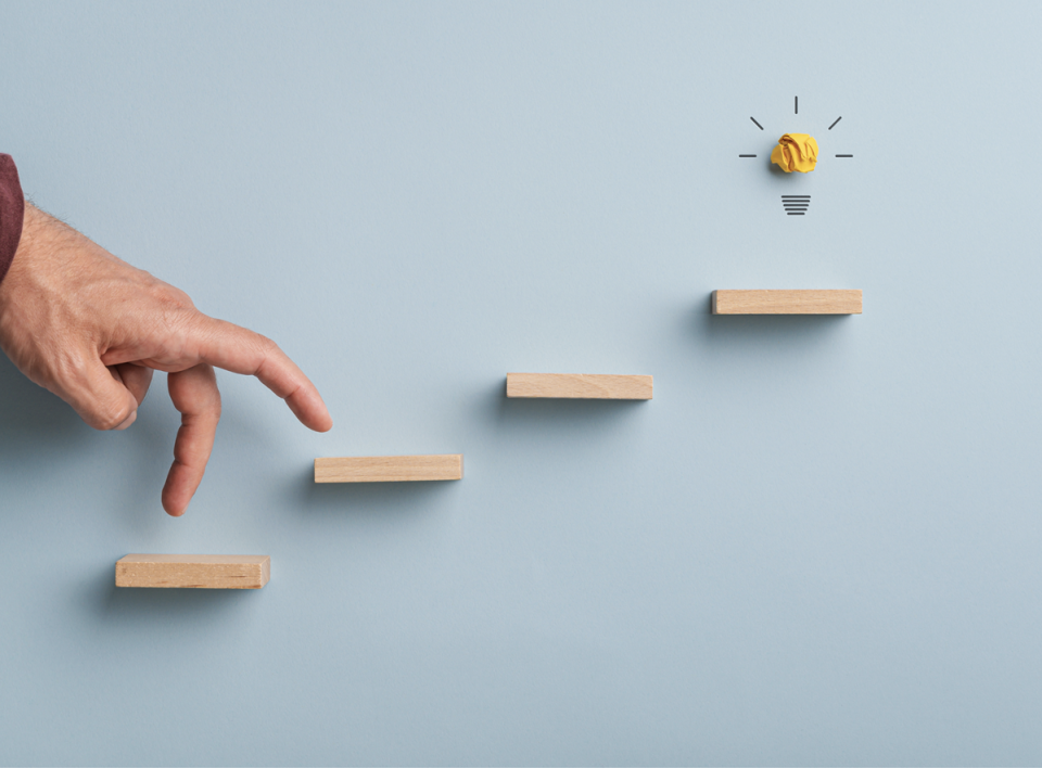 Hands walking up steps to light bulb | Test and Buy Innovation | Digital NSW