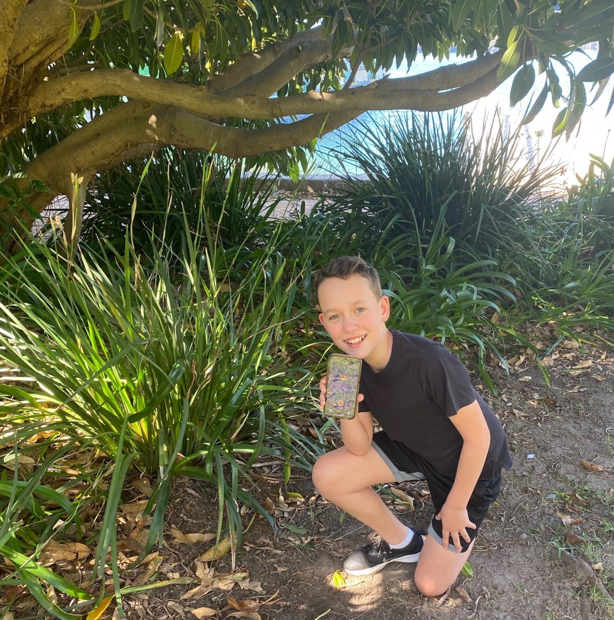 Little boy holding phone with app on it